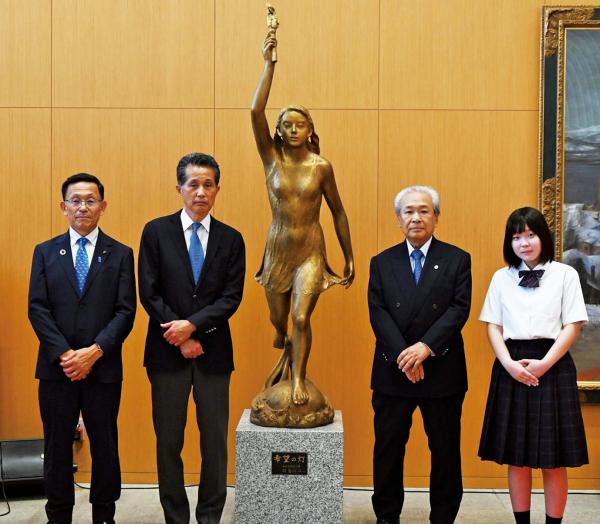 笠間市議会 畑岡 洋二議長、山口市長、 記念銅像「希望の灯」、能島さん、 合併20周年ロゴを制作した県立笠間高等学校 榎本 羽那さん